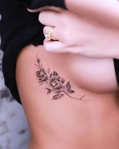 a woman with a rose tattoo on her stomach and the bottom part of her body