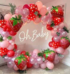 a wreath made out of balloons and strawberries with the word oh baby written on it