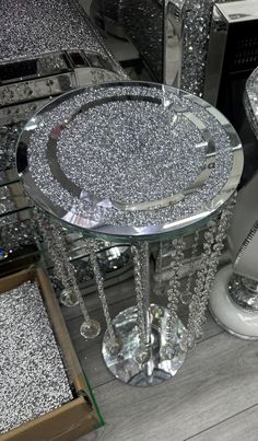 a glass table with silver glitter on it and some other items in the back ground