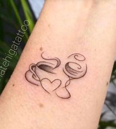 a tattoo on the arm of a woman with two coffee mugs and a heart