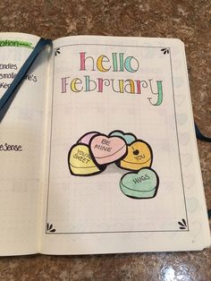 an open notebook with hello february written on the front and back pages, along with two hearts