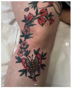 a woman's thigh with flowers and a butterfly on it