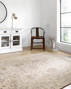 a room with a chair, rug and window