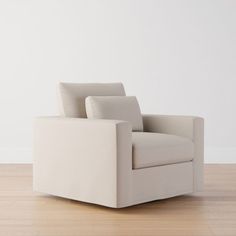 a white chair sitting on top of a hard wood floor next to a white wall