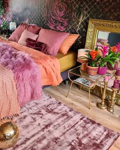 a bedroom with pink and purple decor on the walls, rugs and bedding