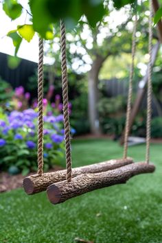 a log swing hanging from a tree in a backyard