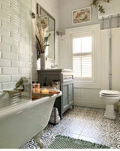 a bathroom with a toilet, sink and bathtub in the middle of it's tiled floor