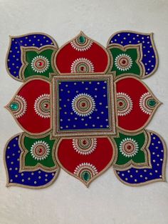 an intricately painted design on the side of a white wall with blue, red and green colors