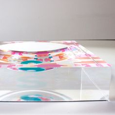 a plate sitting on top of a clear box with an abstract design in the middle