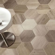 a bathroom with hexagonal tiles on the floor and a round table next to it