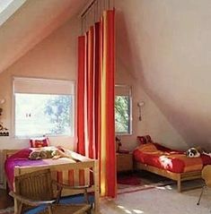 an attic bedroom with two beds and a desk in the corner on the far side