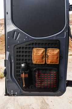 the inside of a vehicle with its door open and two bags in it's compartment