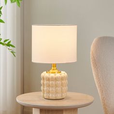 a table with a lamp on it next to a chair