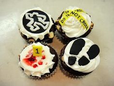 four decorated cupcakes with white frosting and black icing