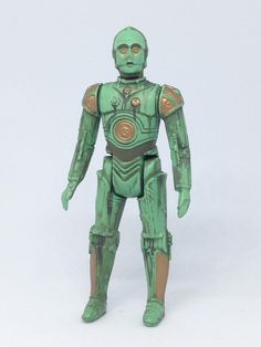 a green robot is standing on a white surface