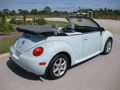 a blue convertible car parked on the side of the road