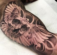 a man's arm with an owl and skull tattoo design on the side of his leg