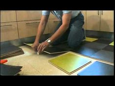 a man kneeling down on the floor with some tiles