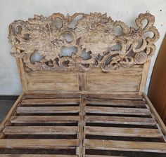 an old wooden bed with intricate carvings on the headboard