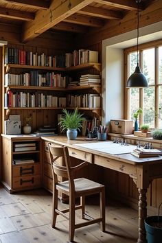 a wooden desk sitting under a window next to a book shelf filled with lots of books