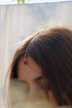 a woman with long hair wearing a gold chain around her neck