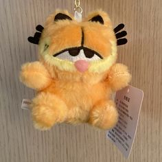 a yellow stuffed animal hanging from a wall with a tag on it's ear