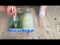 someone is painting on a piece of wood