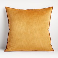 an orange pillow sitting on top of a white table