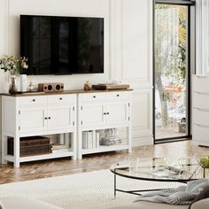 a living room with white furniture and a flat screen tv