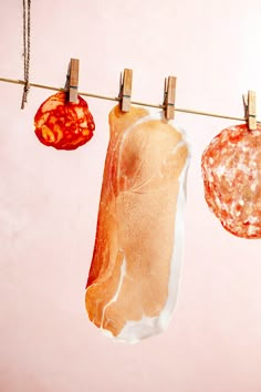 some meat hanging from clothes pins on a line