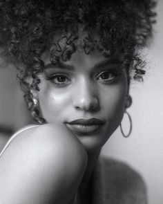 a black and white photo of a woman with curly hair