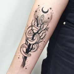 a woman's arm with a snake and tree tattoo on the left inner arm