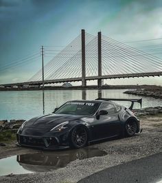 a black sports car parked in front of a bridge