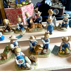 many figurines are sitting on a table with hats and other items around them