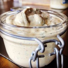 a jar filled with food sitting on top of a wooden table next to a metal chain