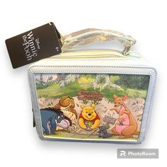 Pack Up For A Picnic In The Hundred Acre Wood With This Loungefly Crossbody Bag! Shaped Like A Lunch Box, This Bag Includes An Embossed Portrait Of Pooh Bear, Owl, Eeyore, Kanga, And Roo On The Front And A Portrait Of Rabbit On The Back. With A Top Handle, Removable Crossbody Strap, And A Zipper Closure, This Bag Is Perfect For Your Next Trip To The Disney Parks And Beyond. Polyurethane; Polyester Approx. 8 1/2" W X 7" H X 4" D Imported New With Tags Disney Style Rectangular Shoulder Bag For Travel, Disney Rectangular Shoulder Bag For Travel, Winnie The Pooh Loungefly Backpack, Loungefly Bags Disney Remy, Loungefly Winnie The Pooh, Eeyore Loungefly, Disney Style Gift Bag, Rectangular Shape, Disney Lunch Box, Disney Rectangular Travel Bag