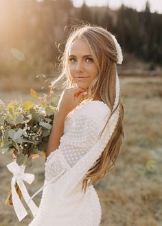 a beautiful young woman holding a bouquet of flowers