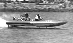 two people riding on the back of a speed boat