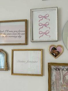 there are many framed pictures on the wall next to each other, including one with a pink ribbon