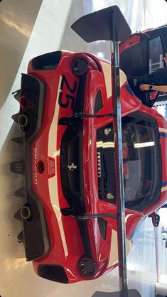 a red sports car is on display in a showroom