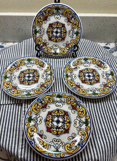 four plates sitting on top of a table covered in blue and white striped cloths