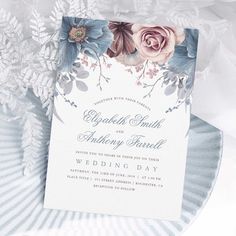 a wedding card with flowers and leaves on the front, sitting on top of a paper plate