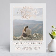 a wedding card with an image of two people sitting on top of a mountain together