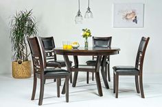 a dining room table with four chairs and a potted plant in the corner next to it