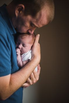 a man holding a baby in his arms