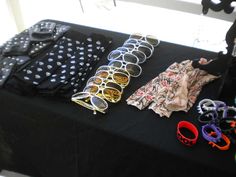 a table topped with lots of different types of sunglasses and clothing on top of it