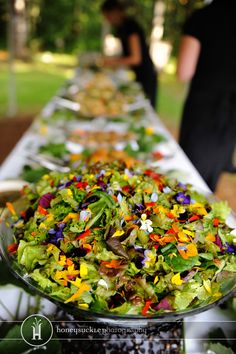 a long table filled with lots of salad