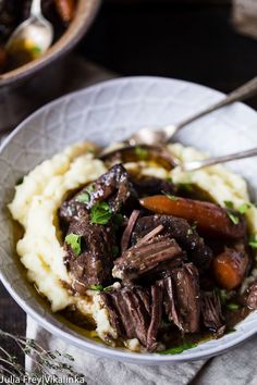 a white bowl filled with meat and mashed potatoes