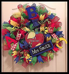 a wreath with the name mrs smith on it is hanging on a door handle that says teacher