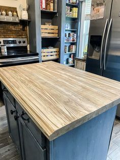 a kitchen island made out of wood in front of a refrigerator